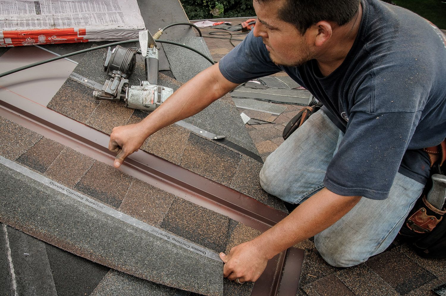 Roofing Contractor Replacing Shingles On Roof Top